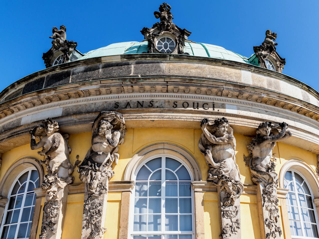 Close-up of Sanssouci Palace's baroque architecture and ornate sculptures in Potsdam, Germany.